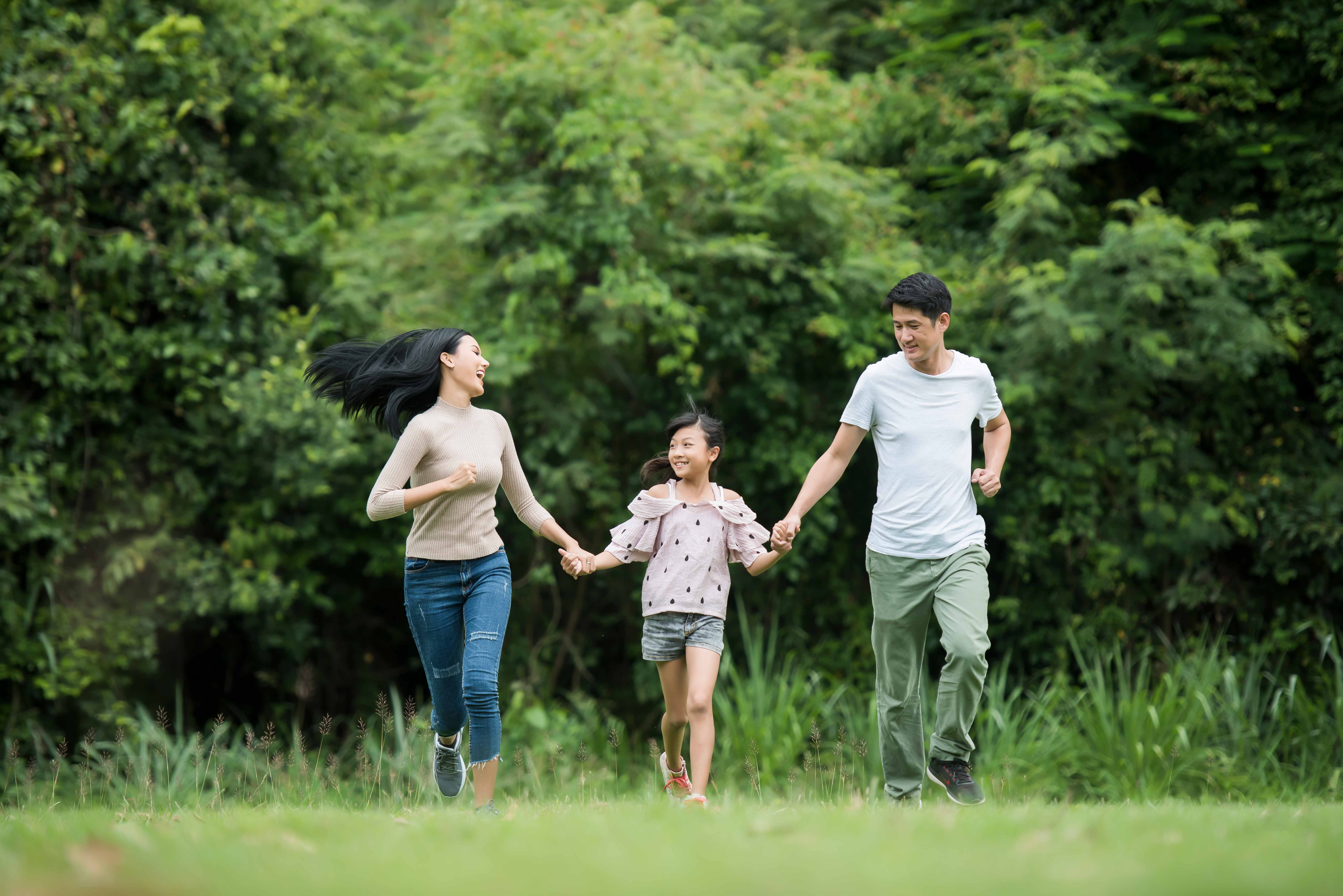happy family is having fun mother father daughter are running park
