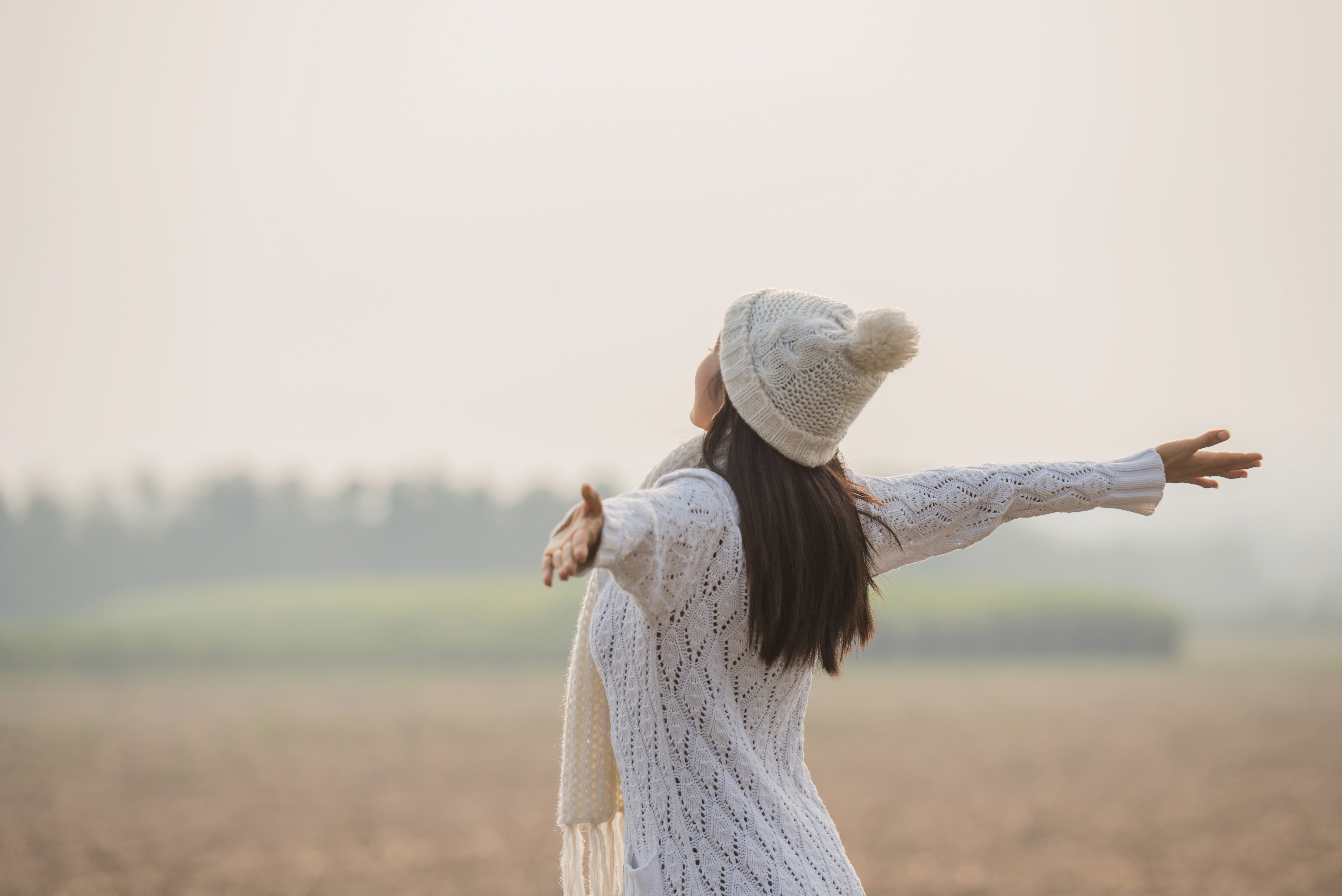 happy woman enjoying idyllic nature celebrating freedom rising her arms